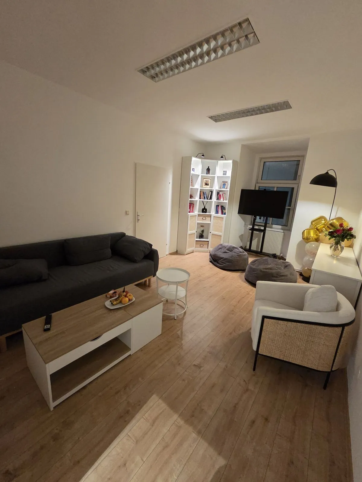 The lounge with a sofa, armchair, bean bags and a bookshelf