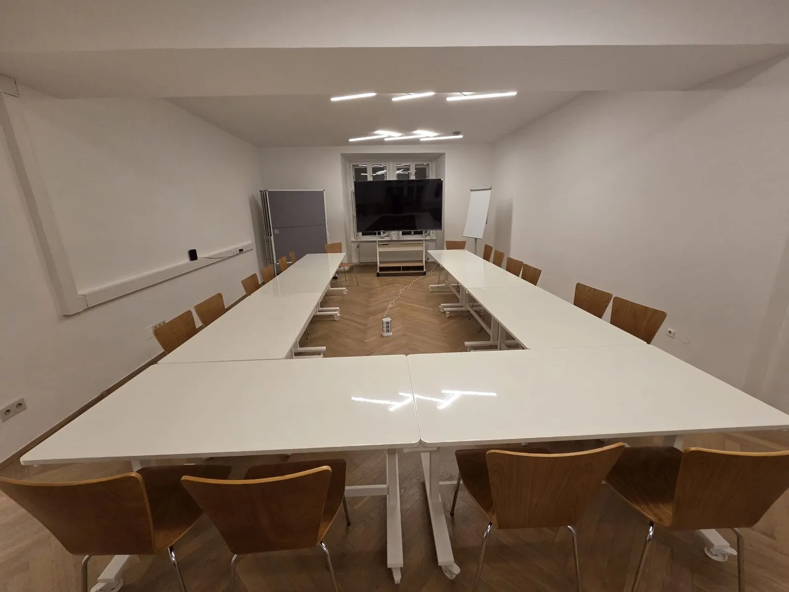 The seminar room with tables in a U-shape, a large screen and a flipchart
