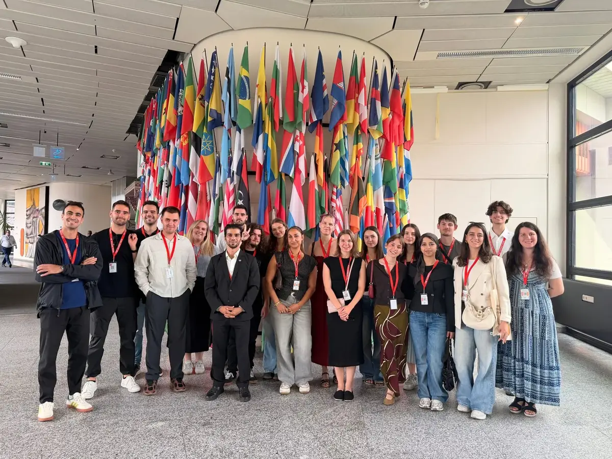 A large group in front of European flags