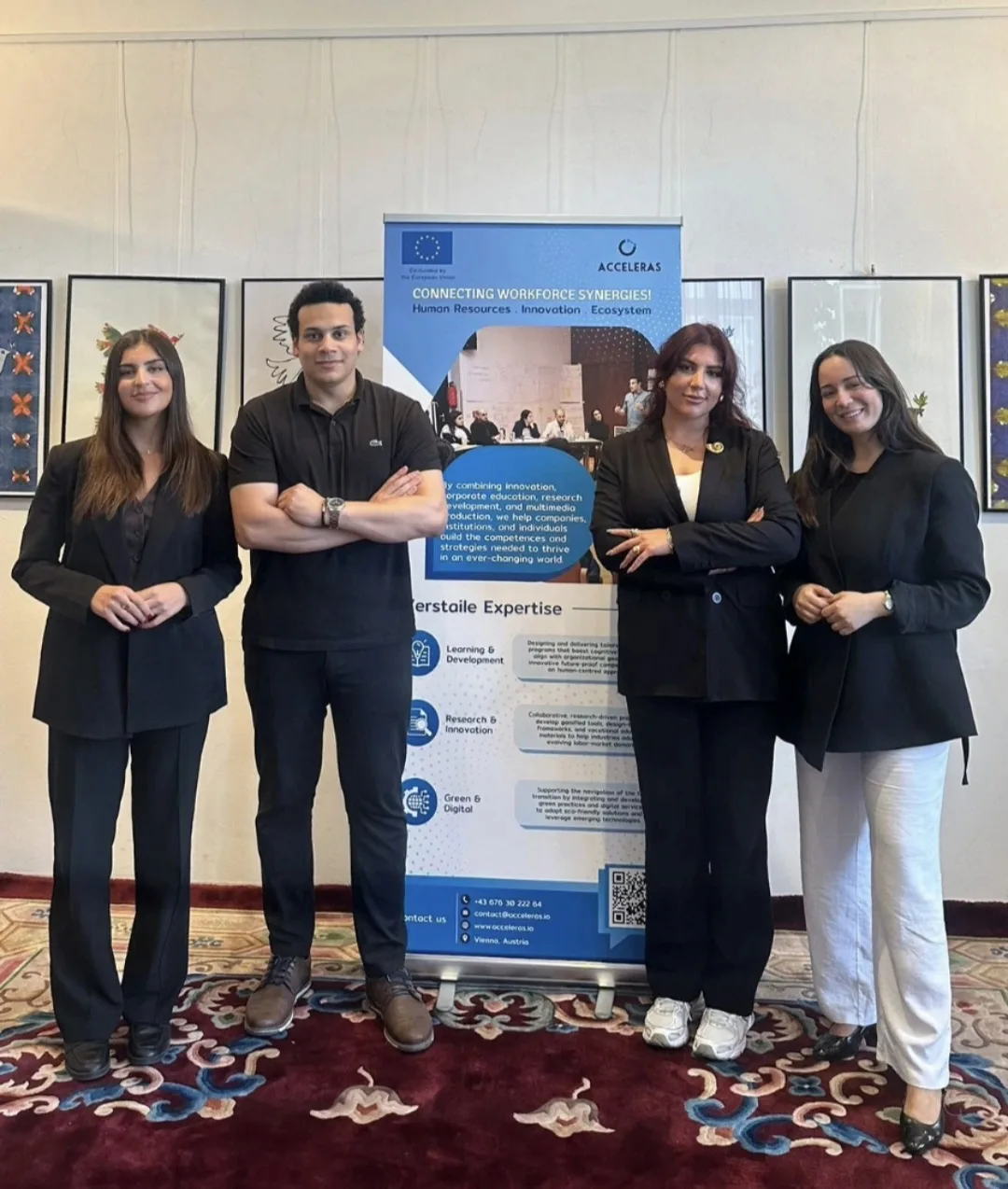 Four people standing next to an ACCELERAS roll-up banner at an event