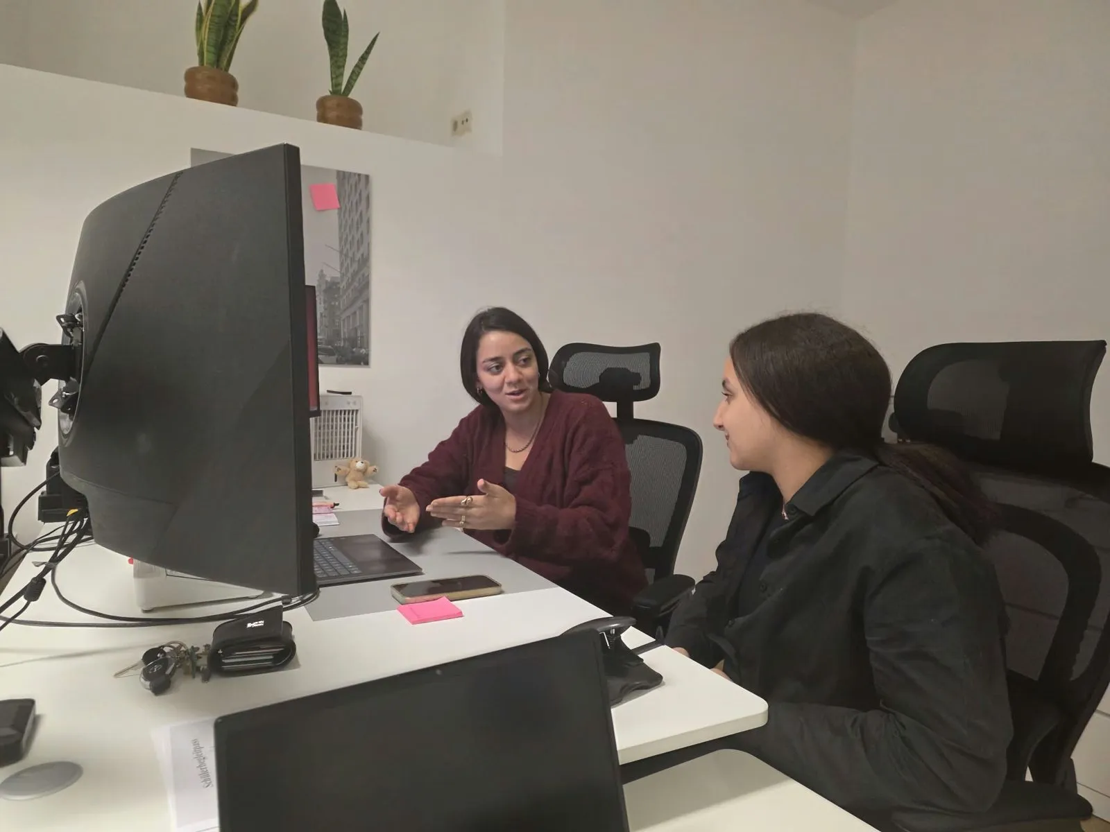 A student talking with a mentor at a desk in our office